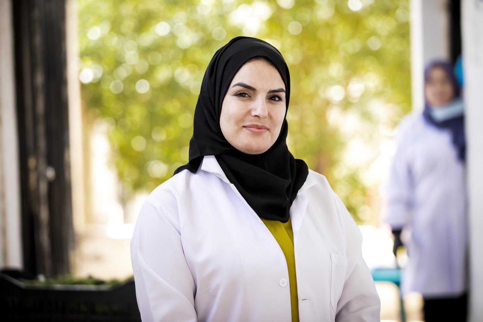 Shireen stands proudly amidst the vibrant Ramtha community-based kitchen garden, overseeing the bustling activity with a smile.